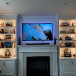 TV monitor over a fireplace that is backlit